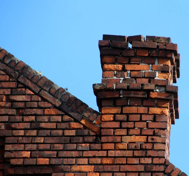 Damaged chimney on an Grand Prairie home showing cracks and missing mortar